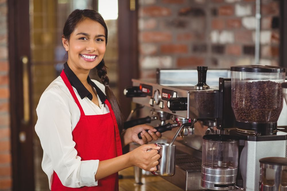 A barista smiling at the camera.